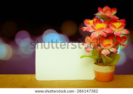 white card and flower vase on blur bokeh light in city in blue tone