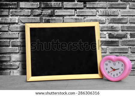 grunge blackboard and pink clock on black and white  brick wall background