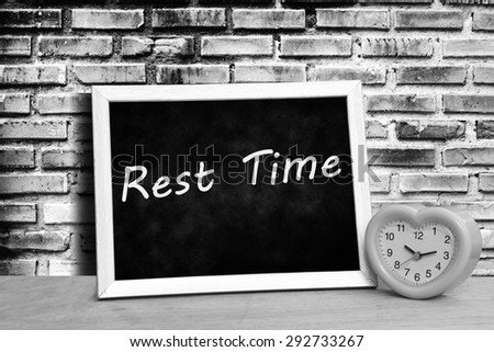 grunge blackboard and pink clock on old dirty brick wall background in black and white tone