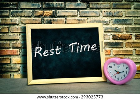 grunge blackboard and pink clock on old dirty brick wall background