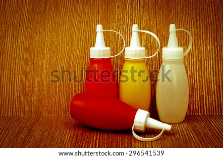small sauce bottle on wooden background in dry paint