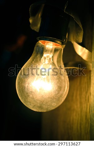 closeup image of light bulb is turn on in the dark,vintage tone