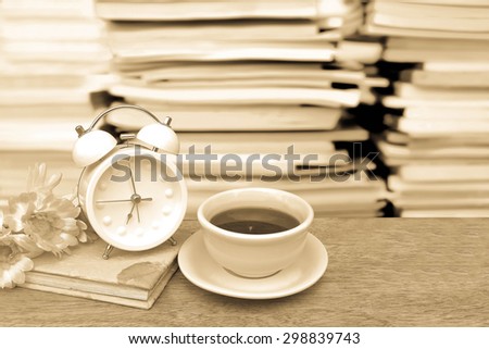 tea and flower on book with blur stacking book background ,vintage tone