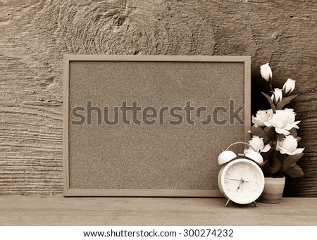 blur cork board with white clock and flower vase with grey wooden plate background ,vintage tone
