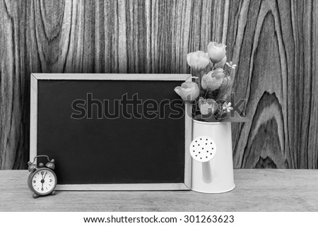 blackboard and watering pot vase with wooden wall background