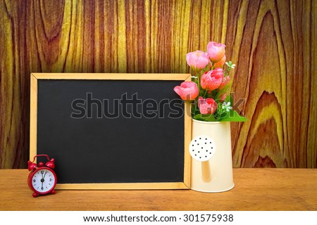 blackboard and watering pot vase with wooden wall background ,vintage tone