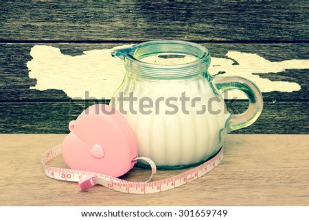 tape measure from heart case binding jug of milk with peeled wooden wall background ,vintage tone