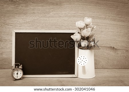 blackboard and vase on wooden background ,vintage tone