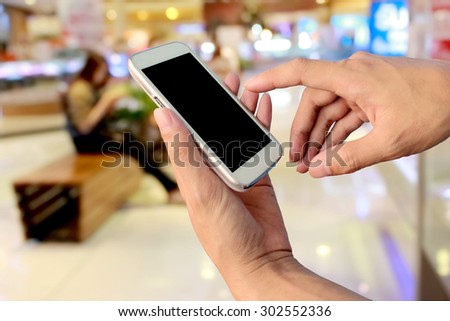 hand of man using mobile phone blur image of people are using mobile phone