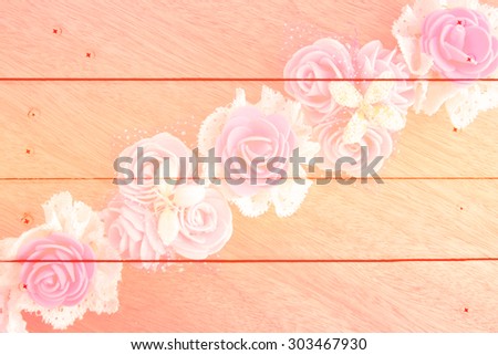 artificial flower on wooden wall and nails background with color filter