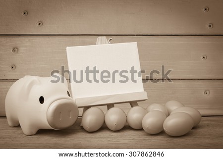 piggy bank and canvas frame with wooden wall background  ,vintage tone