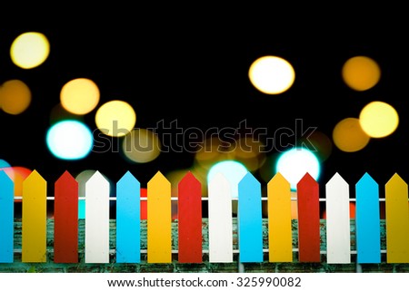 color wooden fence with scented candles on white pebble and stone with blur dark ocean and light background