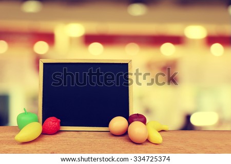blackboard and artificial food with blur light in restaurant background