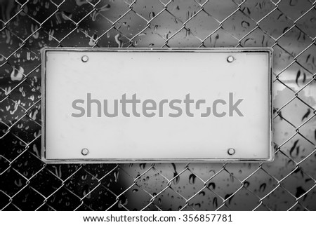 blank license plate on net fence and blur drop on mirror background