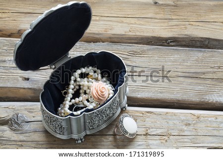 jewels in an open jewelry box, on wood