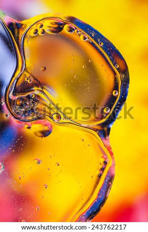 Colorful abstract shot of oil and water mixed together to show interesting bubbles patterns and shapes.  Ideal as vivid bright background, taken in portrait format.  Mostly yellow.