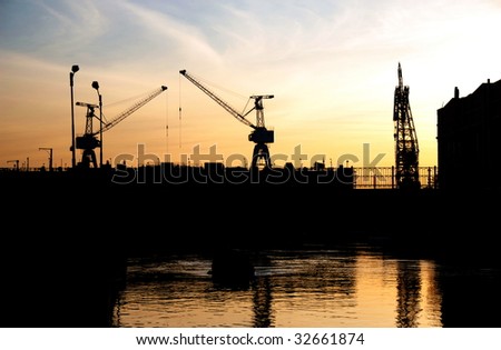 Silhouette of portal cranes in harbor, shot during sunset