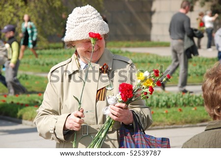 ST.PETERSBURG – MAY 9: An unidentified woman prepares flowers for veterans at the Piskaryovskoye cemetery on May 9, 2009 in St.Petersburg. About 500,000 victims of the Nazi regime are buried there.