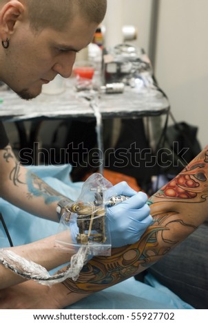 stock photo : SAINT PETERSBURG - JUNE 20: Tattoo artist at work at St.