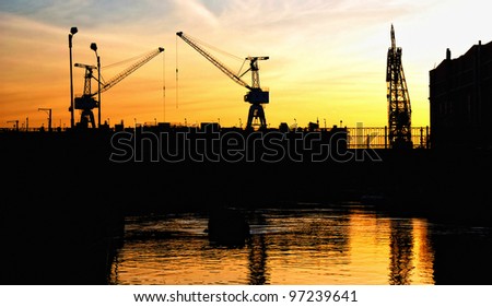 Silhouette of portal cranes in harbor, shot during sunset