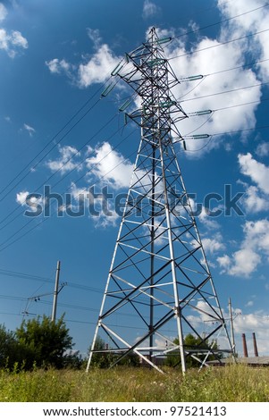 Electric power station in the field in blue cloudy sky