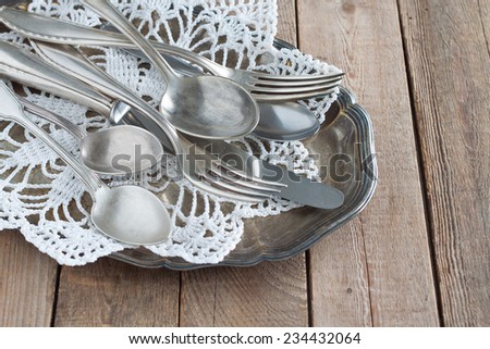 Old cutlery on a silver platter