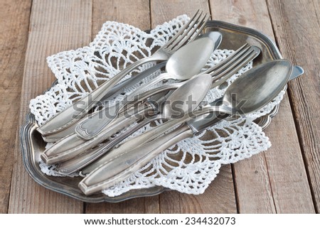 Old cutlery on a silver platter