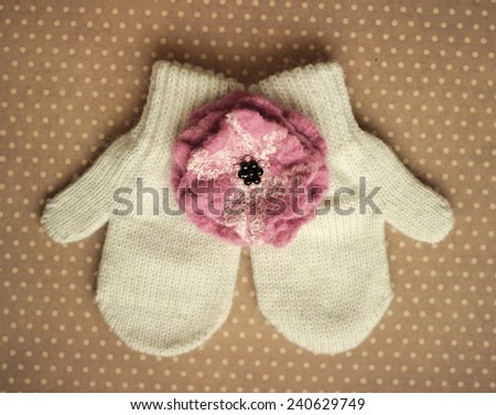 white mittens and wool flower