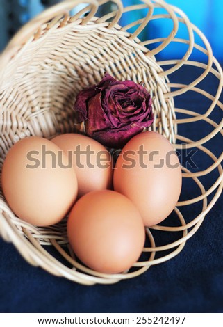 eggs and dry rose in a basket