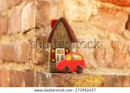 real estate. little house and car on brick background
