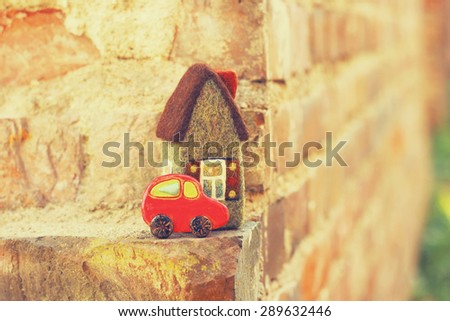 toy house and car, brick background