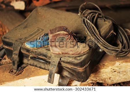 vintage still life: dusty suitcase, old child shoes