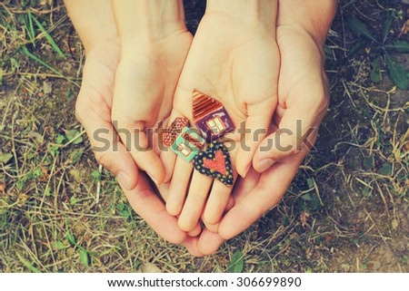 decorative houses and heart in hands of young couple; dream