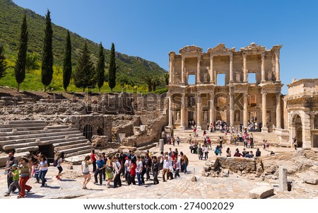 Ephesus, Turkey - April, 26, 2014: A group of tourists gather around a tour guide in the celsus library area of Ephesus in order to hear the guide tell them about the site