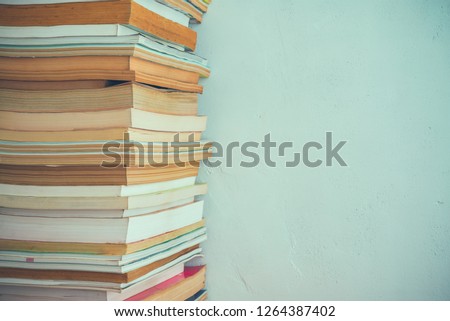 Stack of many old books on shelf in book store or library room with white wall background. Knowledge learning, education, bachelor degree in university or back to school concept.