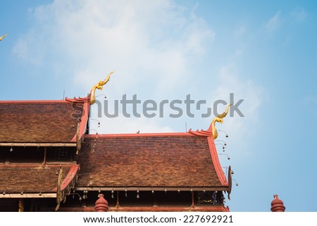 Beautiful roof tiles of temple in Chiang mai, Thailand blue sky - public