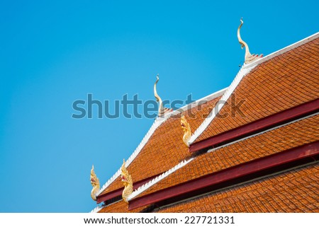 Beautiful roof tiles of temple in Chiang mai, Thailand against blue sky - public place