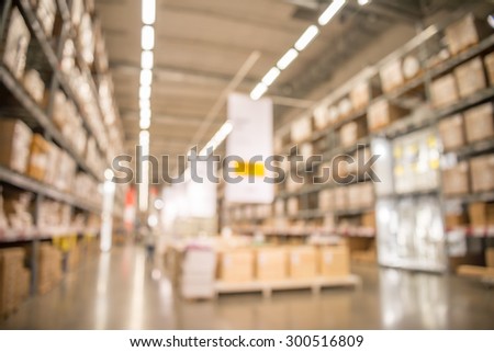 Abstract blurred boxes on rows of shelves in big modern warehouse background