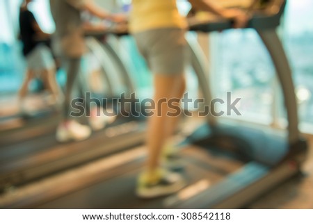 Women run in modern gym fitness center abstract blur background