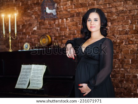 pregnant woman in a black dress at the piano