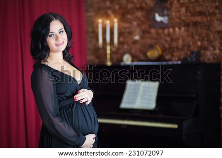 pregnant woman in a black dress at the piano