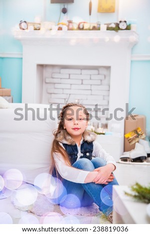 little girl sitting by the fireplace