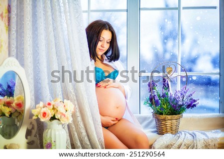Pregnancy, motherhood and happy future mother concept - beautiful pregnant woman  in lingerie home, dreams of a future child  near window