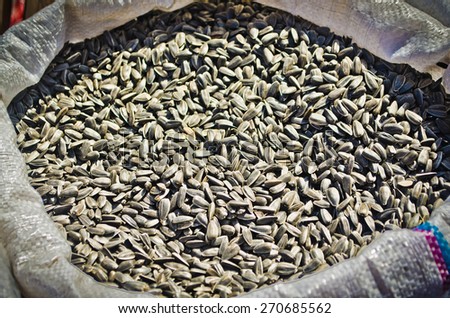 Bags of dry sunflower seeds from the market as a textured food background. Shallow DOF, focus on lower third.