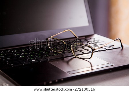Blank business laptop, mouse and glasses