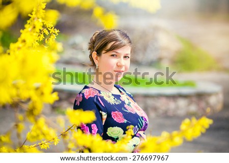 girl  near the bush with yellow flowers