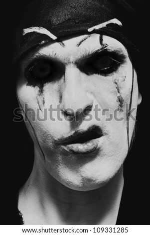 theatrical actor with dark makeup on his face close up