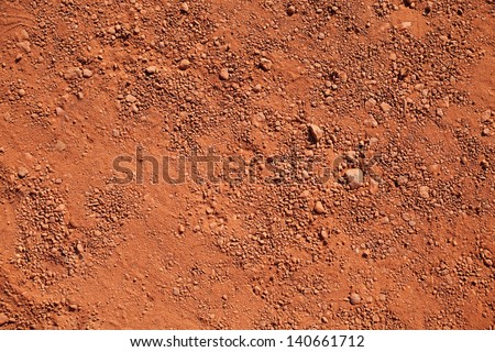 Texture Of Dry Red Clay With Stones Close-Up
