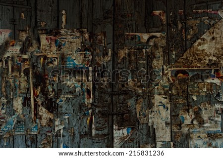 old wooden gate with scraps of classified ads close-up