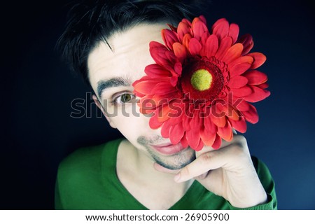 portrait of a young guy with a flower on a black background